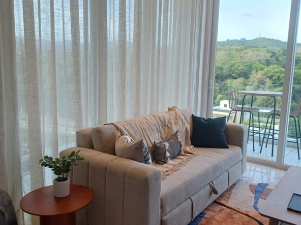 living room with couch large window curtains